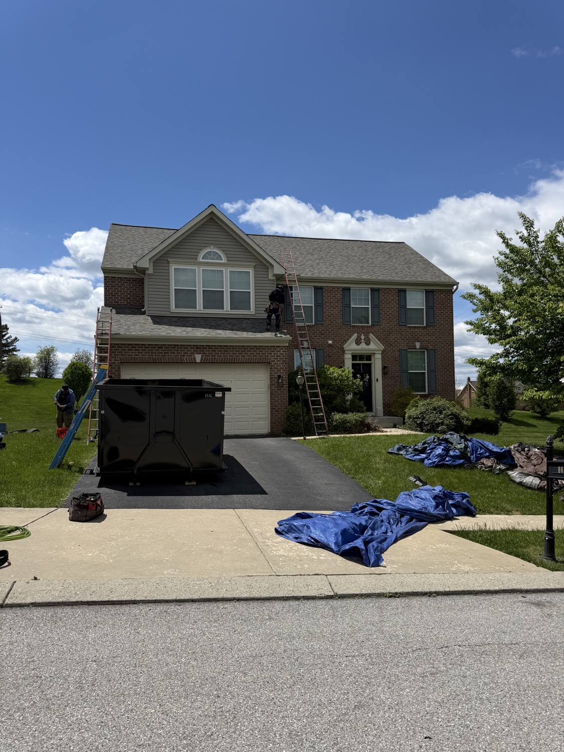 Diamond Elite Roofing crew completing a roof replacement on a brick colonial in Maryland.
